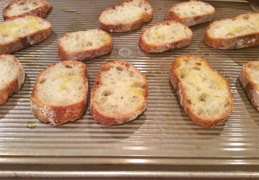 Baguette cut into think slices, on cookie sheet, with a little olive oil drizzled on top.